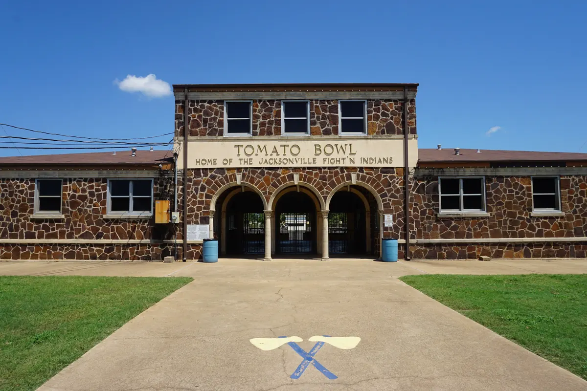 The stone entrance of the Tomato Bowl stadium in Jacksonville, with three arches under a sign for the Jacksonville Fightin' Indians.